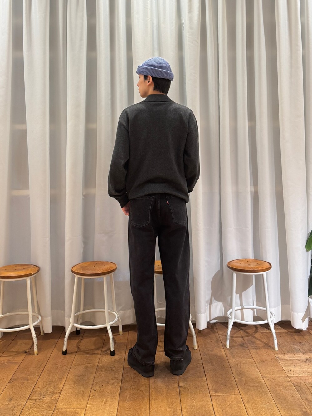 グレー系のカーディガン/ボレロ、ブラック系のデニムパンツ、ブラック系のブーツを着用したメンズの秋コーディネートの4枚目の写真
