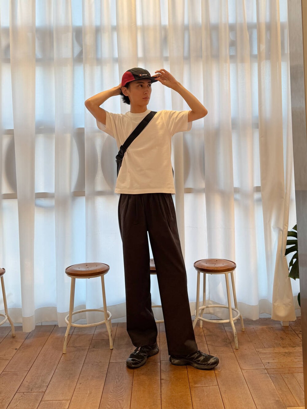 ブラック系のショルダーバッグ、ブラック系のスニーカー、ホワイト系のTシャツ/カットソーを着用したメンズの夏コーディネートの4枚目の写真