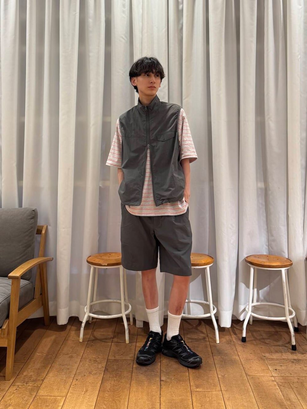 グレー系のベスト、グレー系のその他パンツ、ブラック系のスニーカーを着用したメンズの春コーディネートの5枚目の写真