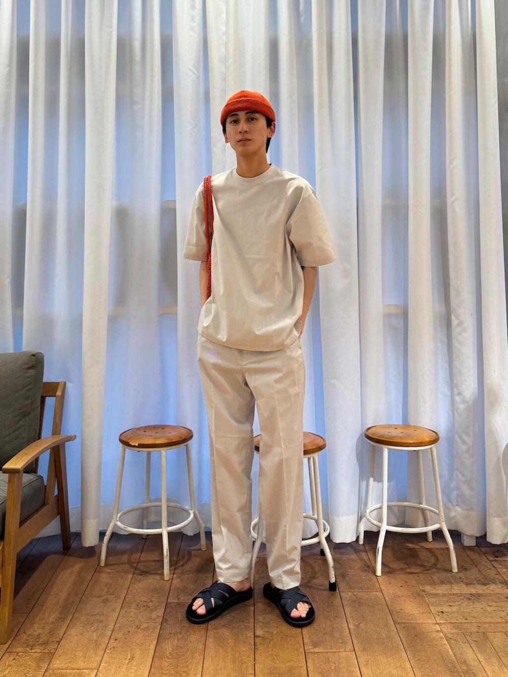 オレンジ系のトートバッグ、グレー系のTシャツ/カットソー、グレー系のその他パンツを着用したメンズの春コーディネートの5枚目の写真