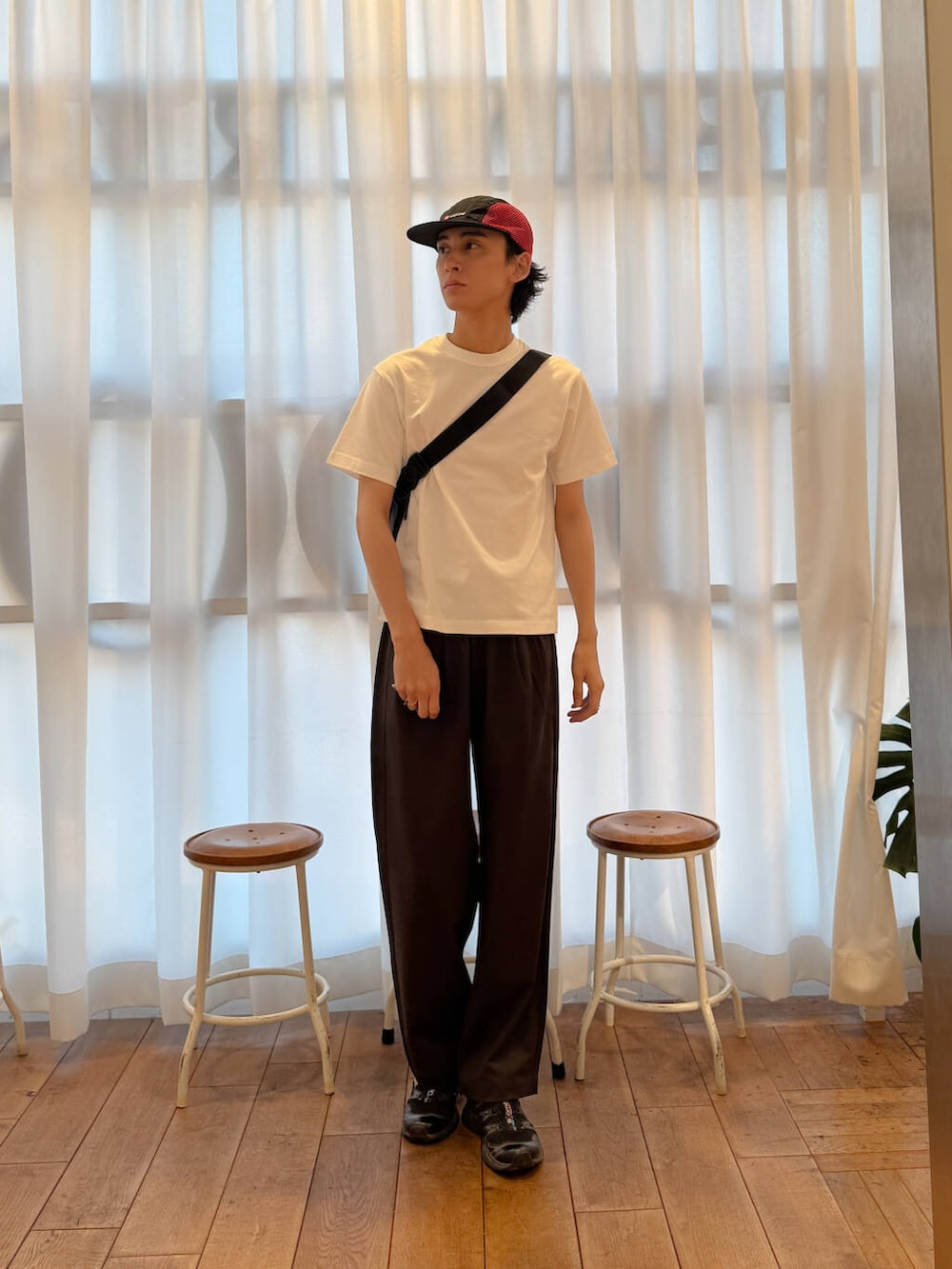 ブラック系のショルダーバッグ、ブラック系のスニーカー、ホワイト系のTシャツ/カットソーを着用したメンズの夏コーディネートの5枚目の写真