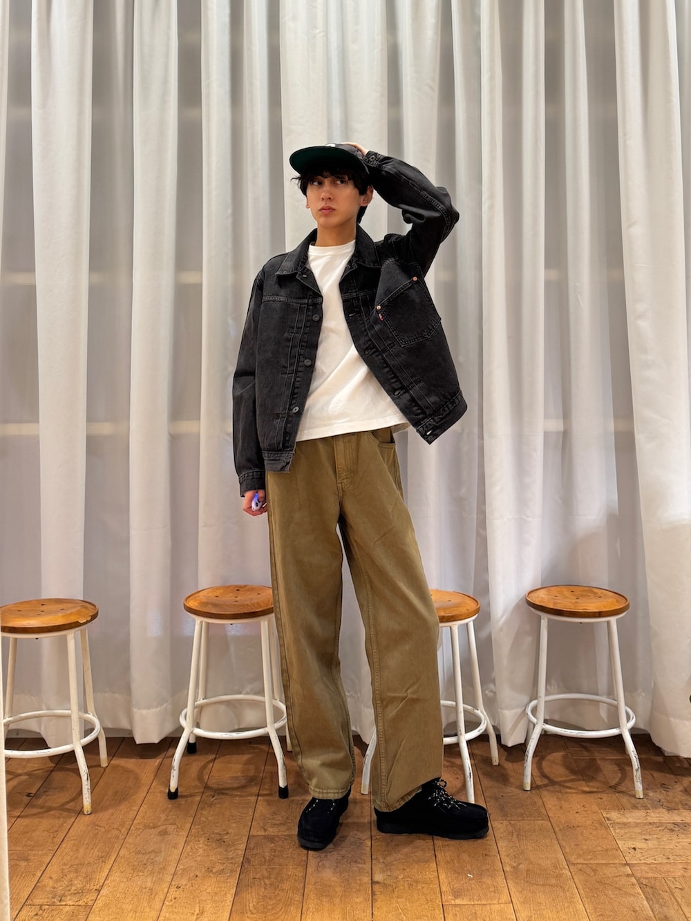 ブラック系のデニムジャケット、ブラック系のブーツ、ホワイト系のTシャツ/カットソーを着用したメンズの夏コーディネートの3枚目の写真