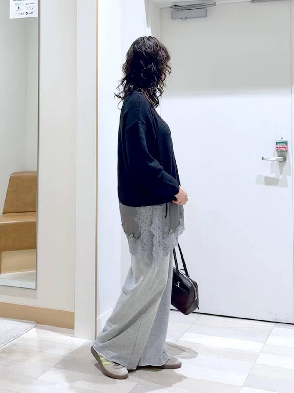 グレー系のスウェットパンツ、ブラック系のタンクトップ、ブラウン系のショルダーバッグを着用したレディースの春コーディネートの3枚目の写真