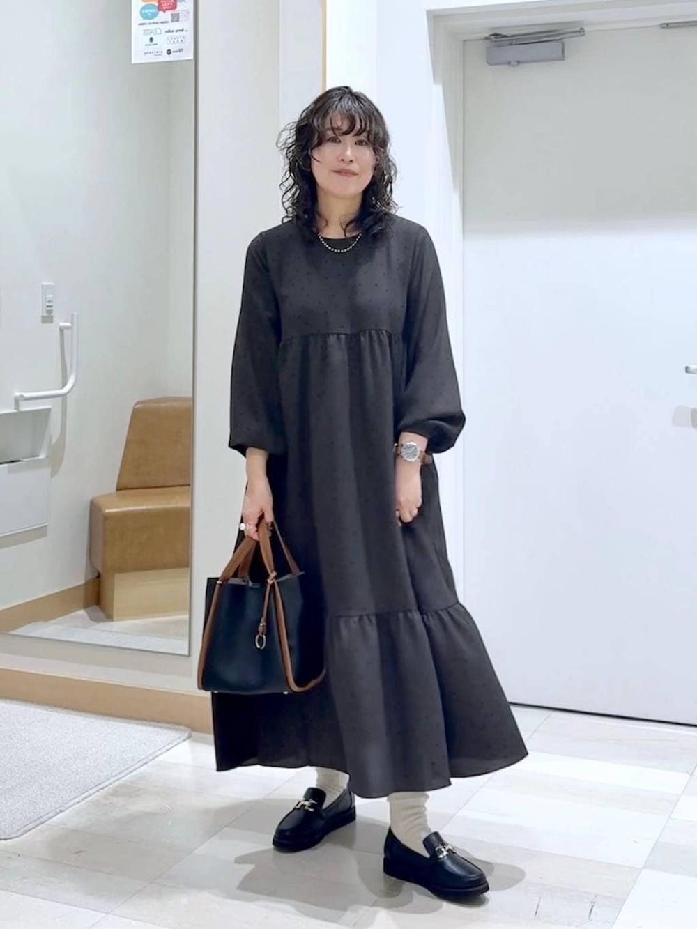 ブラック系のローファー、ブラック系のトートバッグ、ブラウン系のワンピースを着用したレディースの春コーディネートの5枚目の写真