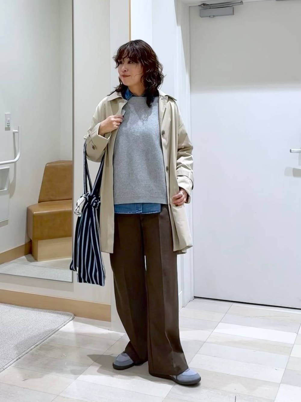 ブルー系のシャツ/ブラウス、ブラウン系のその他パンツ、グレー系のニット/セーターを着用したレディースの春コーディネートの2枚目の写真