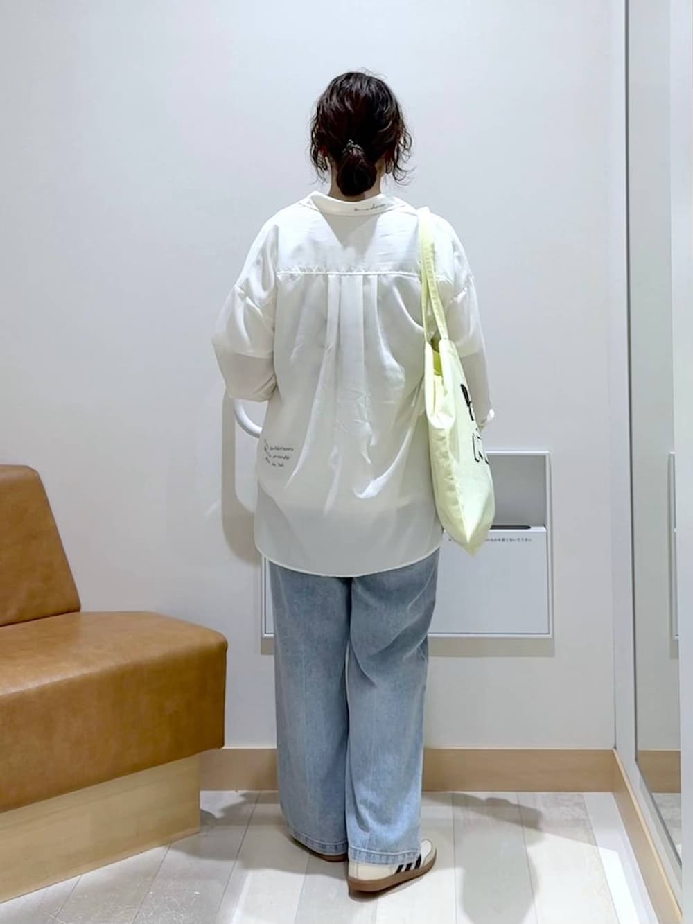 ブラック系のベスト、ホワイト系のTシャツ/カットソー、イエロー系のトートバッグを着用したレディースの秋コーディネートの4枚目の写真