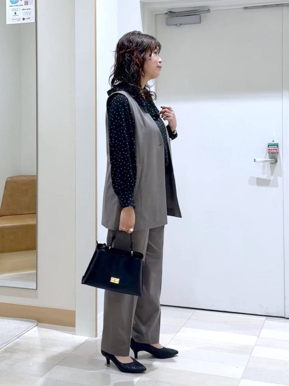 ブラック系のパンプス、ブラウン系のスラックス、ブラウン系のその他アウターを着用したレディースの春コーディネートの3枚目の写真