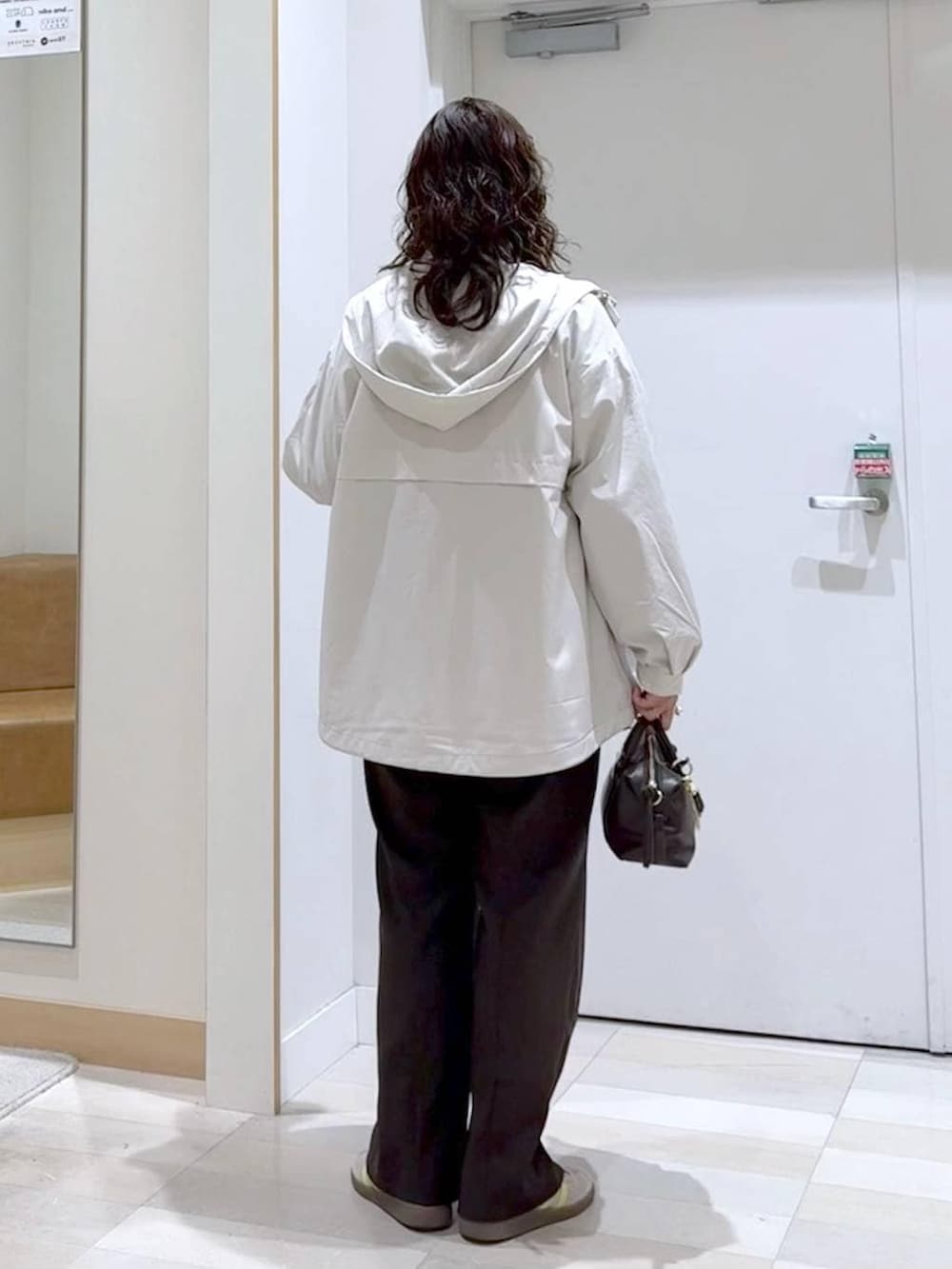 ブラウン系のその他パンツ、ベージュ系のマウンテンパーカー、ブルー系のシャツ/ブラウスを着用したレディースの春コーディネートの4枚目の写真