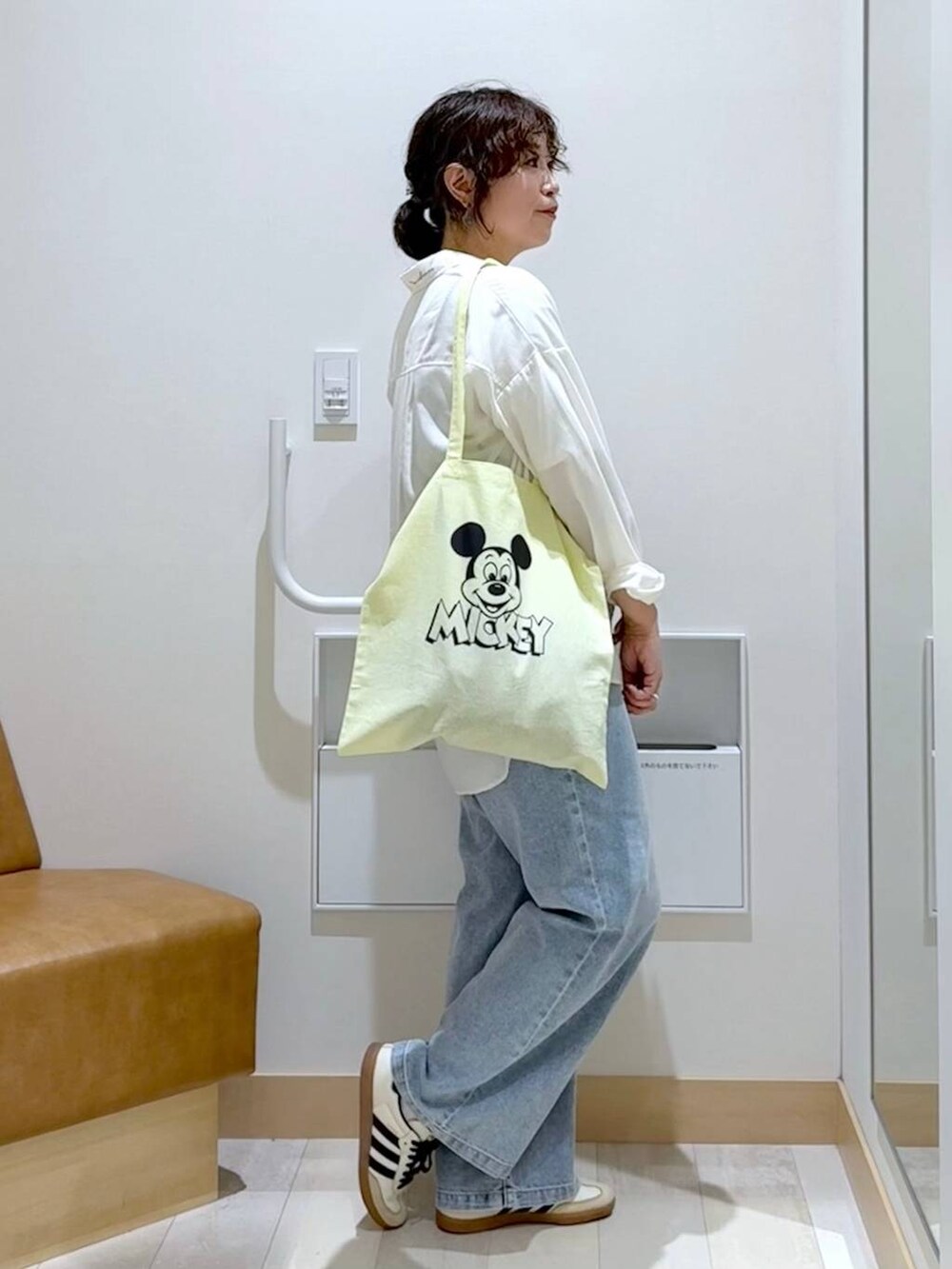 ブラック系のベスト、ホワイト系のTシャツ/カットソー、イエロー系のトートバッグを着用したレディースの秋コーディネートの3枚目の写真