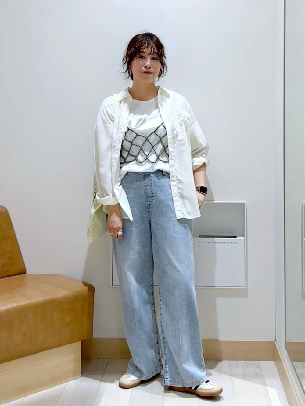 ブラック系のベスト、ホワイト系のTシャツ/カットソー、イエロー系のトートバッグを着用したレディースの秋コーディネートの2枚目の写真
