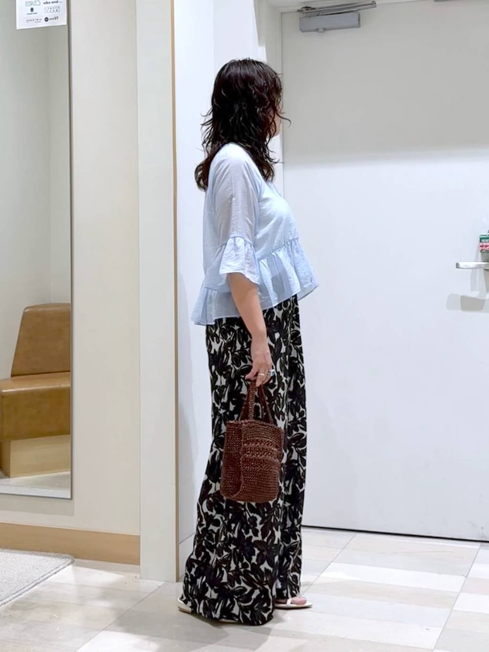 ベージュ系のその他パンツ、ホワイト系のタンクトップ、ブラウン系のクラッチバッグを着用したレディースの夏コーディネートの3枚目の写真