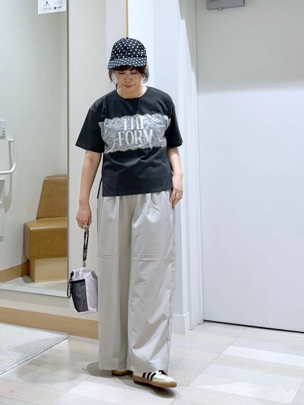 ベージュ系のその他パンツ、ピンク系のボディバッグ/ウエストポーチ、ブラック系のTシャツ/カットソーを着用したレディースの夏コーディネートの2枚目の写真