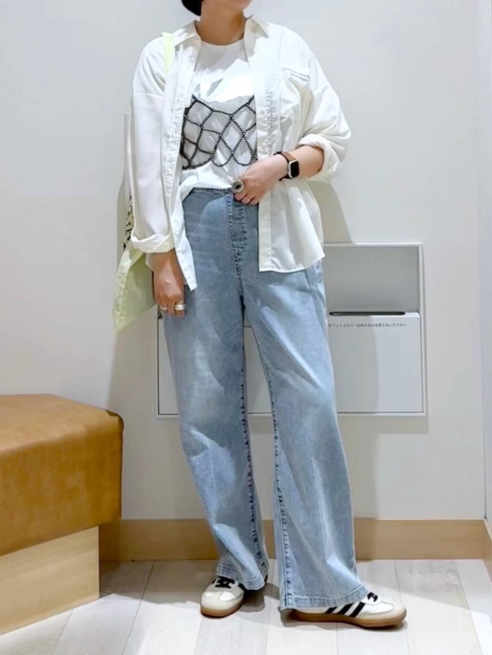 ブラック系のベスト、ホワイト系のTシャツ/カットソー、イエロー系のトートバッグを着用したレディースの秋コーディネートの5枚目の写真