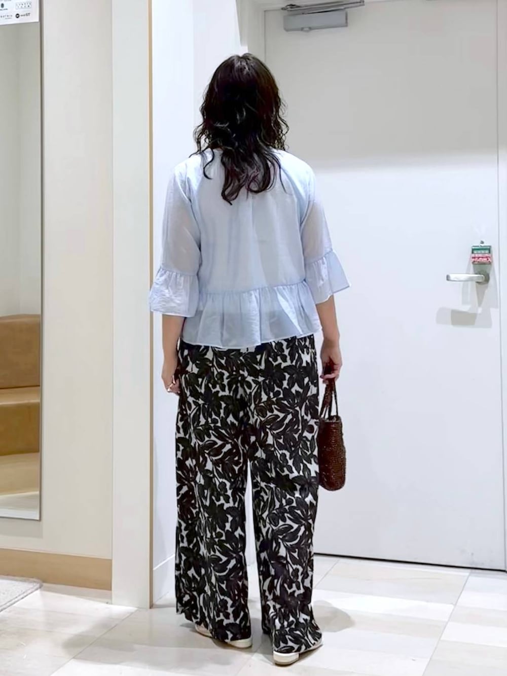 ベージュ系のその他パンツ、ホワイト系のタンクトップ、ブラウン系のクラッチバッグを着用したレディースの夏コーディネートの4枚目の写真