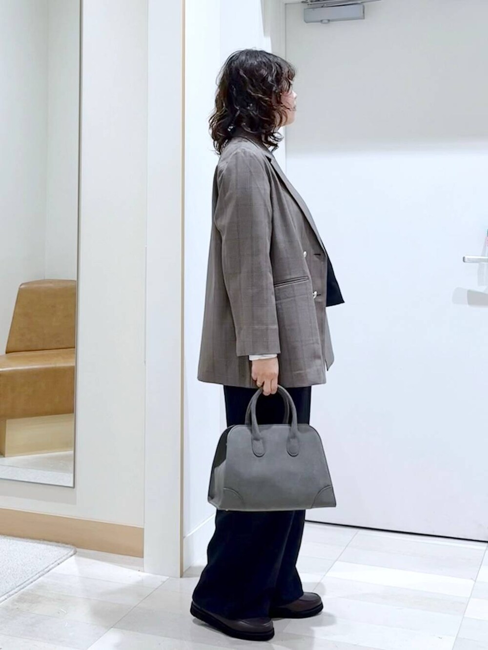 ブラウン系のローファー、グリーン系のショルダーバッグ、ブラック系のサロペット/オーバーオールを着用したレディースの秋コーディネートの3枚目の写真