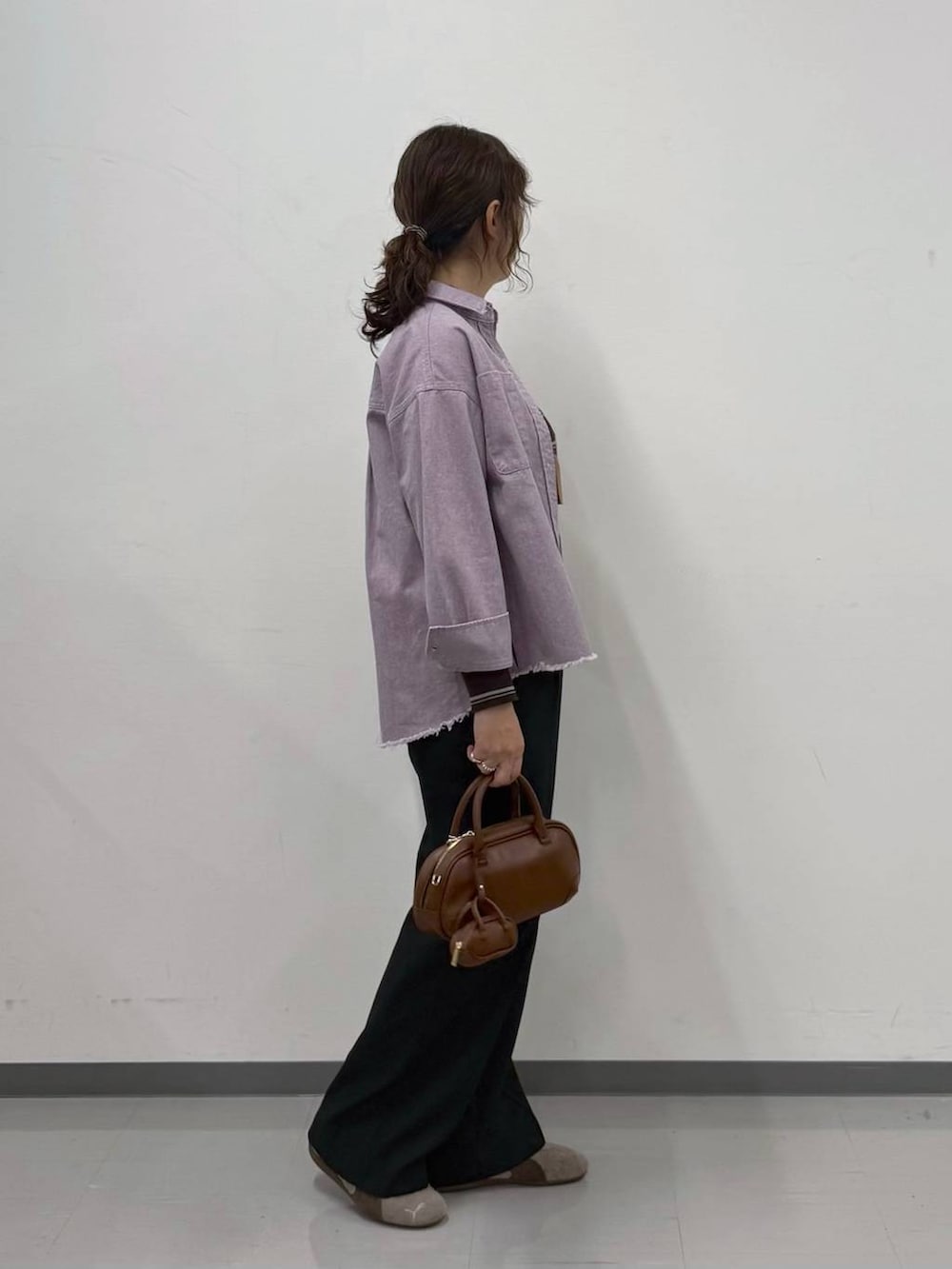 ブラウン系のニット/セーター、ブラック系のその他パンツ、ブラウン系のハンドバッグを着用したレディースの春コーディネートの3枚目の写真