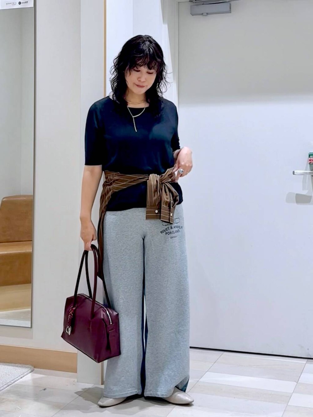 グレー系のスウェットパンツ、ホワイト系のその他シューズ、レッド系のボストンバッグを着用したレディースの夏コーディネートの2枚目の写真