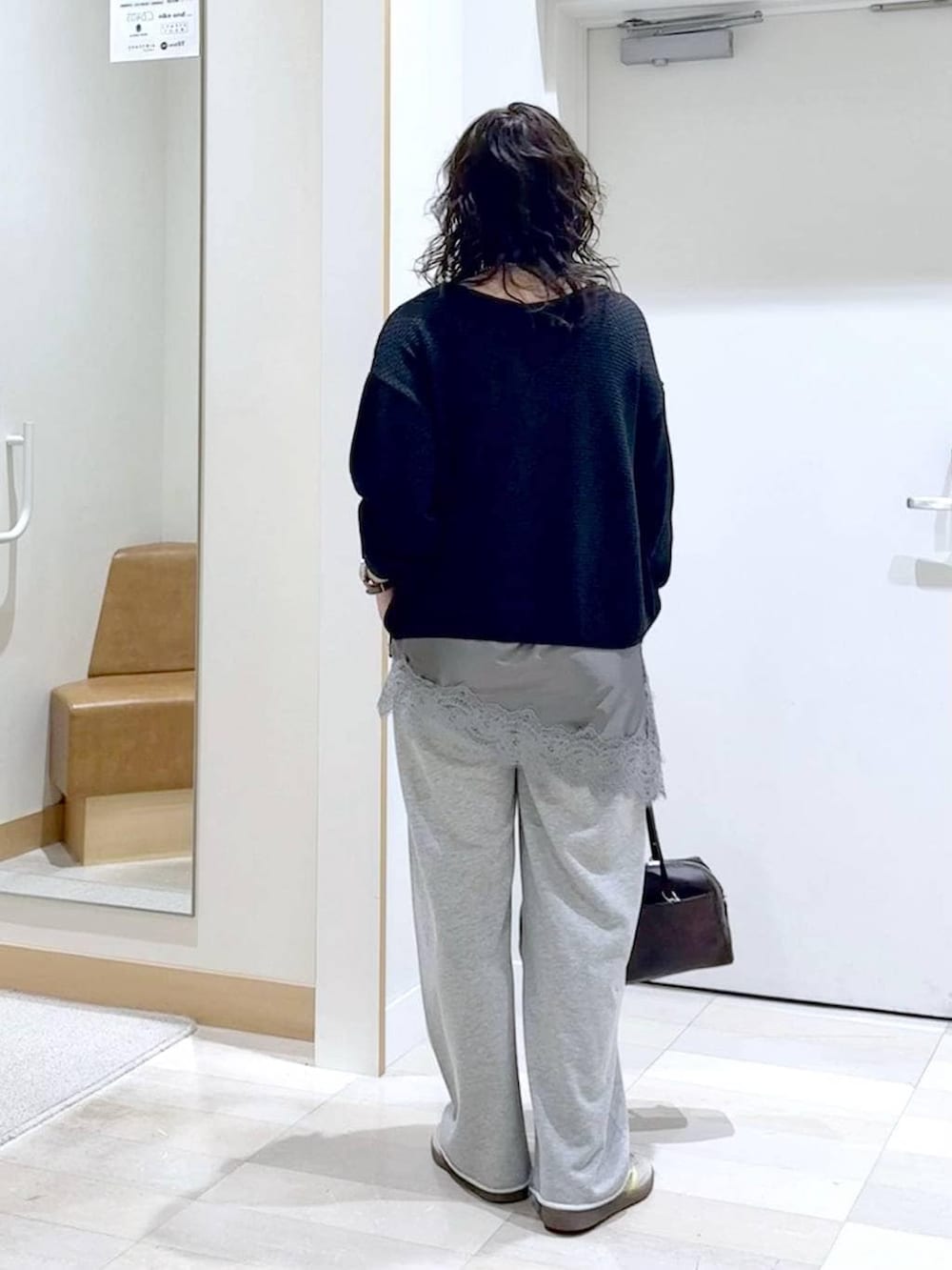 グレー系のスウェットパンツ、ブラック系のタンクトップ、ブラウン系のショルダーバッグを着用したレディースの春コーディネートの4枚目の写真