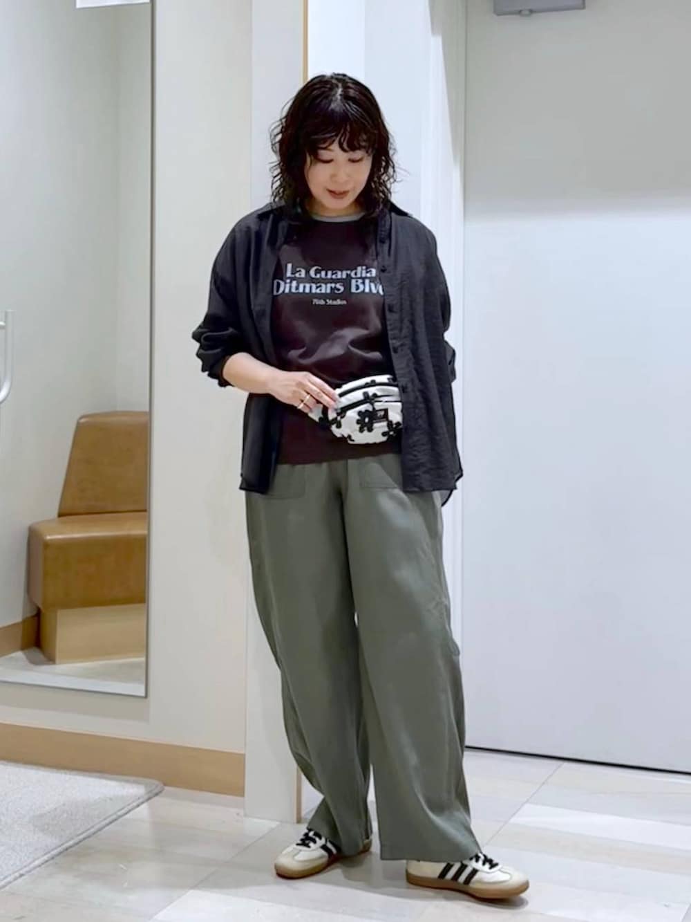 グレー系のシャツ/ブラウス、ホワイト系のボディバッグ/ウエストポーチ、ブラウン系のTシャツ/カットソーを着用したレディースの夏コーディネートの3枚目の写真