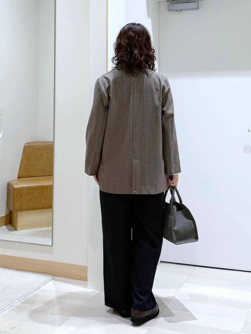 ブラウン系のローファー、グリーン系のショルダーバッグ、ブラック系のサロペット/オーバーオールを着用したレディースの秋コーディネートの4枚目の写真