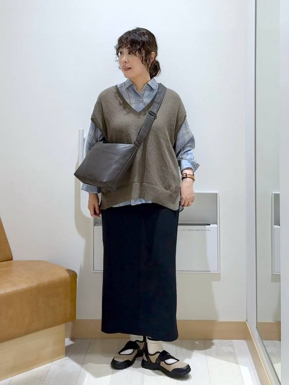ベージュ系のスニーカー、ブラック系のスカート、ブラウン系のベストを着用したレディースの夏コーディネートの2枚目の写真