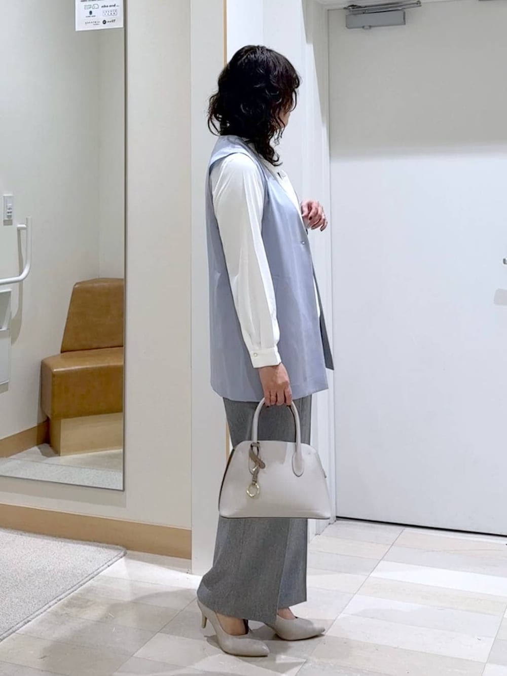 ホワイト系のショルダーバッグ、ホワイト系のパンプス、ホワイト系のシャツ/ブラウスを着用したレディースの春コーディネートの2枚目の写真