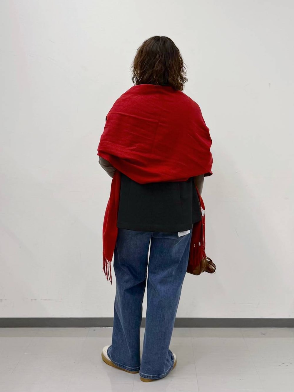 ホワイト系のローファー、ブルー系のデニムパンツ、ブラウン系のハンドバッグを着用したレディースの春コーディネートの4枚目の写真