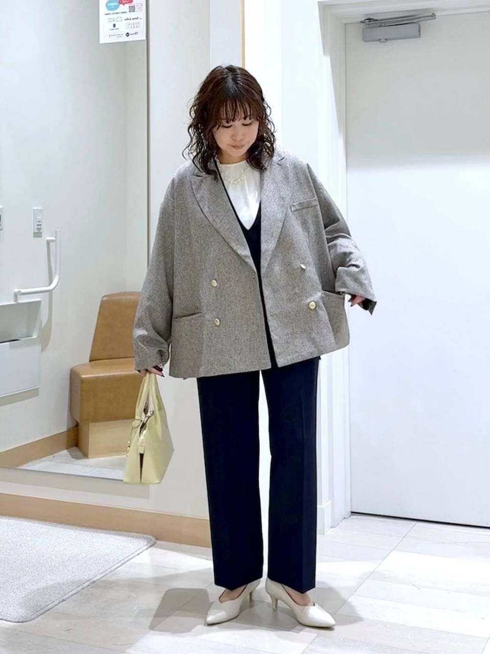 イエロー系のショルダーバッグ、ホワイト系のパンプス、ブルー系のセットアップを着用したレディースの春コーディネートの2枚目の写真