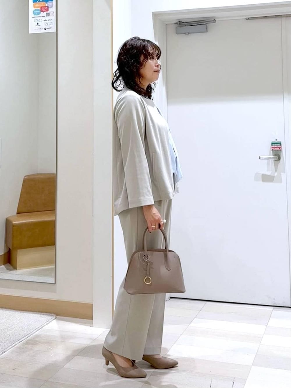 ベージュ系のショルダーバッグ、ベージュ系のパンプス、ブルー系のシャツ/ブラウスを着用したレディースの春コーディネートの3枚目の写真