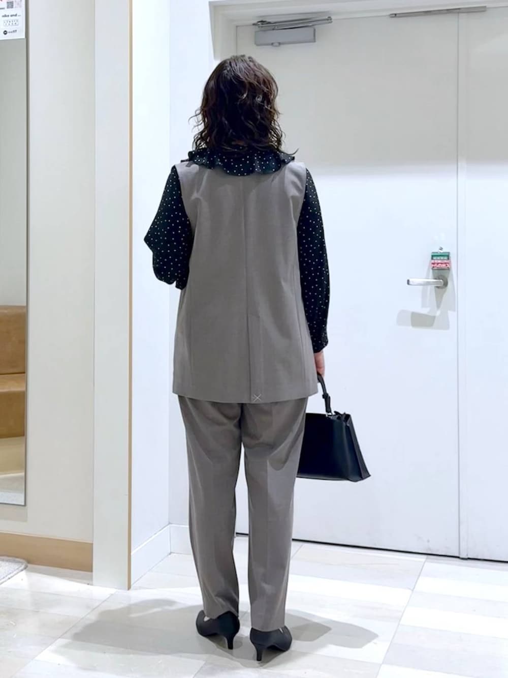 ブラック系のパンプス、ブラウン系のスラックス、ブラウン系のその他アウターを着用したレディースの春コーディネートの4枚目の写真