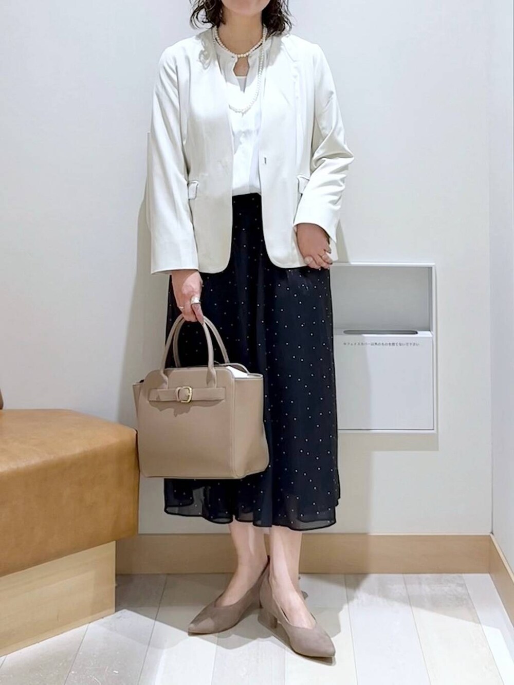ホワイト系のノーカラージャケット、ホワイト系のシャツ/ブラウス、ベージュ系のパンプスを着用したレディースの春コーディネートの5枚目の写真