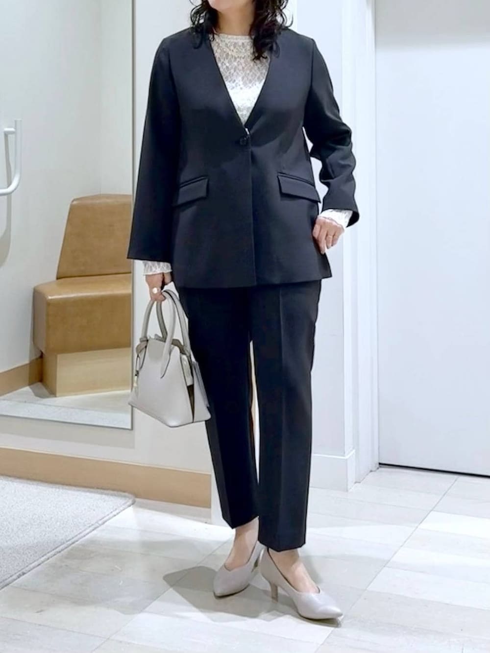 ホワイト系のショルダーバッグ、ホワイト系のパンプス、ホワイト系のTシャツ/カットソーを着用したレディースの冬コーディネートの5枚目の写真