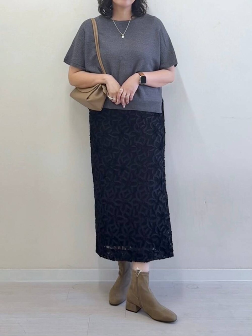 グレー系のニット/セーター、ベージュ系のショルダーバッグ、ブラック系のスカートを着用したレディースの夏コーディネートの5枚目の写真