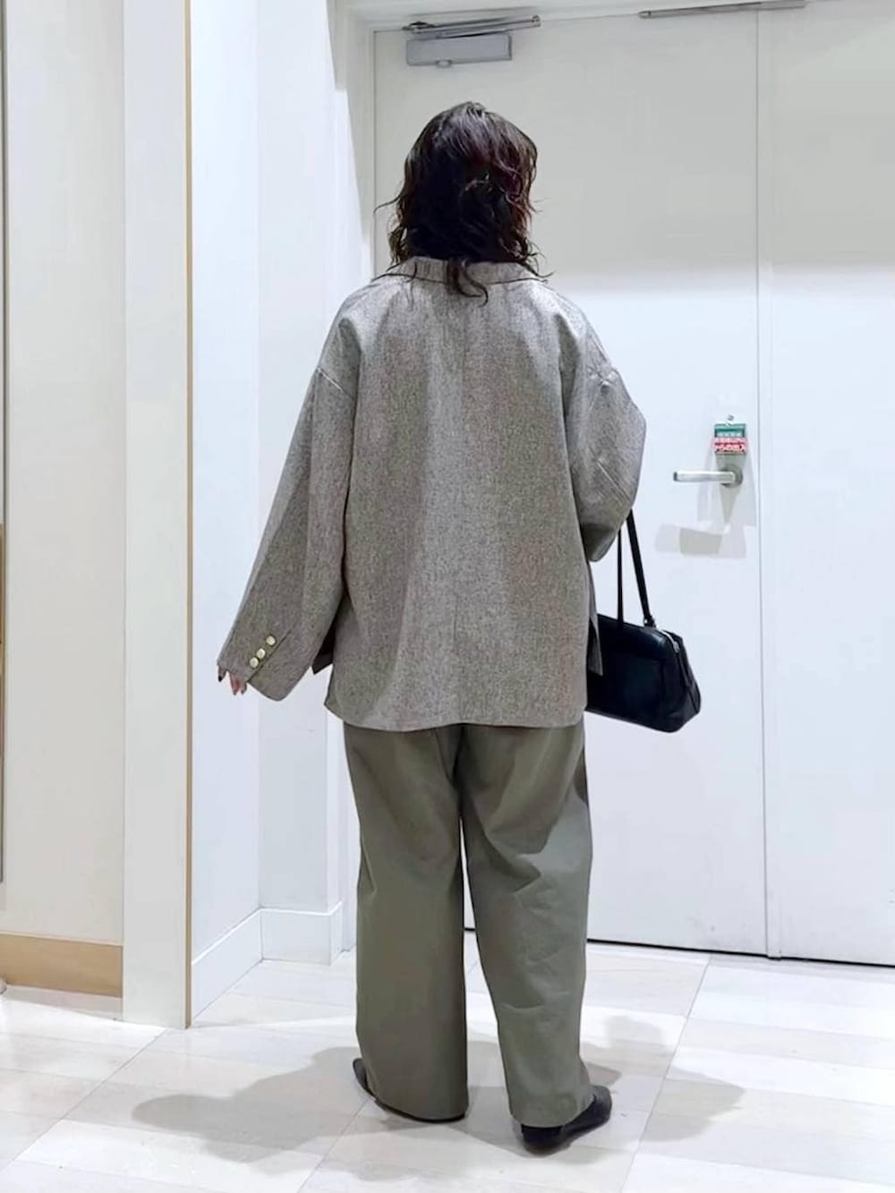 ブラック系のパンプス、ホワイト系のTシャツ/カットソー、ブラック系のショルダーバッグを着用したレディースの春コーディネートの4枚目の写真