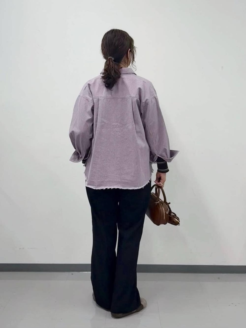 ブラウン系のニット/セーター、ブラック系のその他パンツ、ブラウン系のハンドバッグを着用したレディースの春コーディネートの4枚目の写真