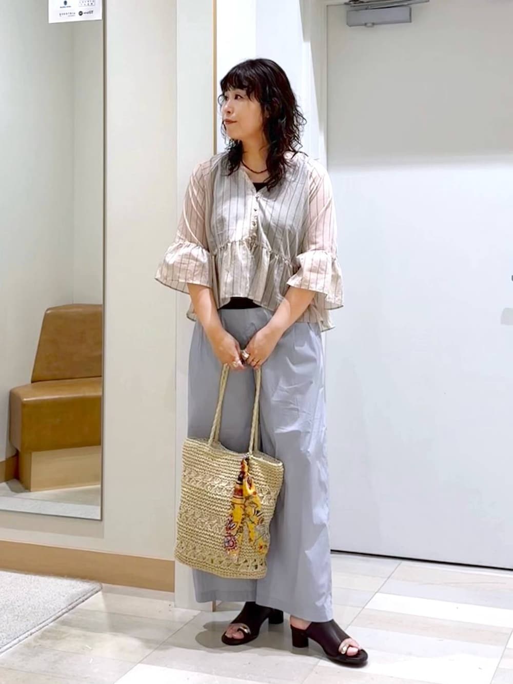 グレー系のその他パンツ、ブラウン系のタンクトップ、ベージュ系のトートバッグを着用したレディースの夏コーディネートの2枚目の写真
