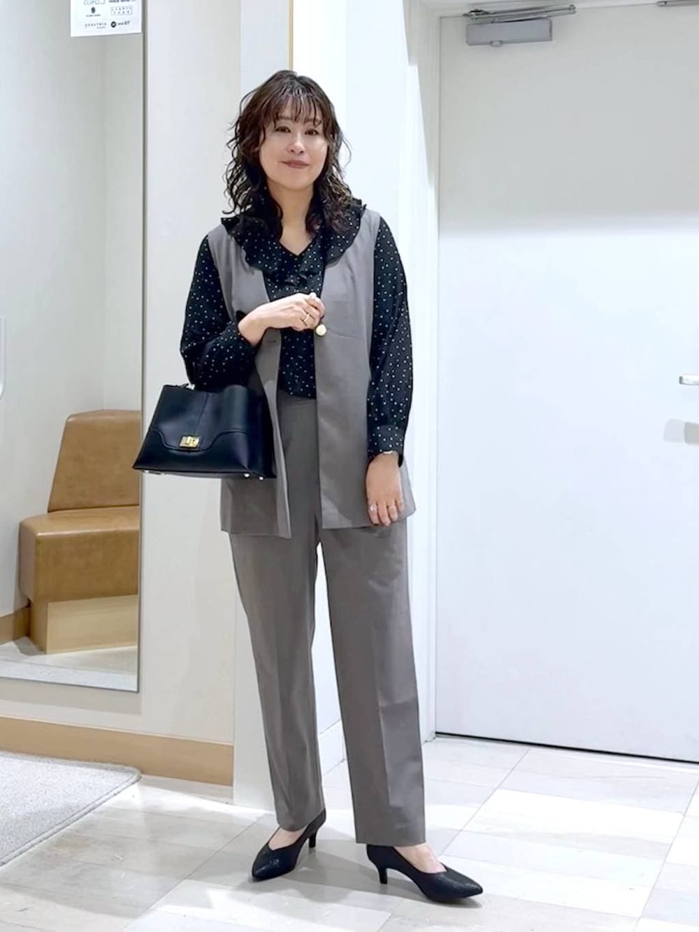 ブラック系のパンプス、ブラウン系のスラックス、ブラウン系のその他アウターを着用したレディースの春コーディネートの2枚目の写真