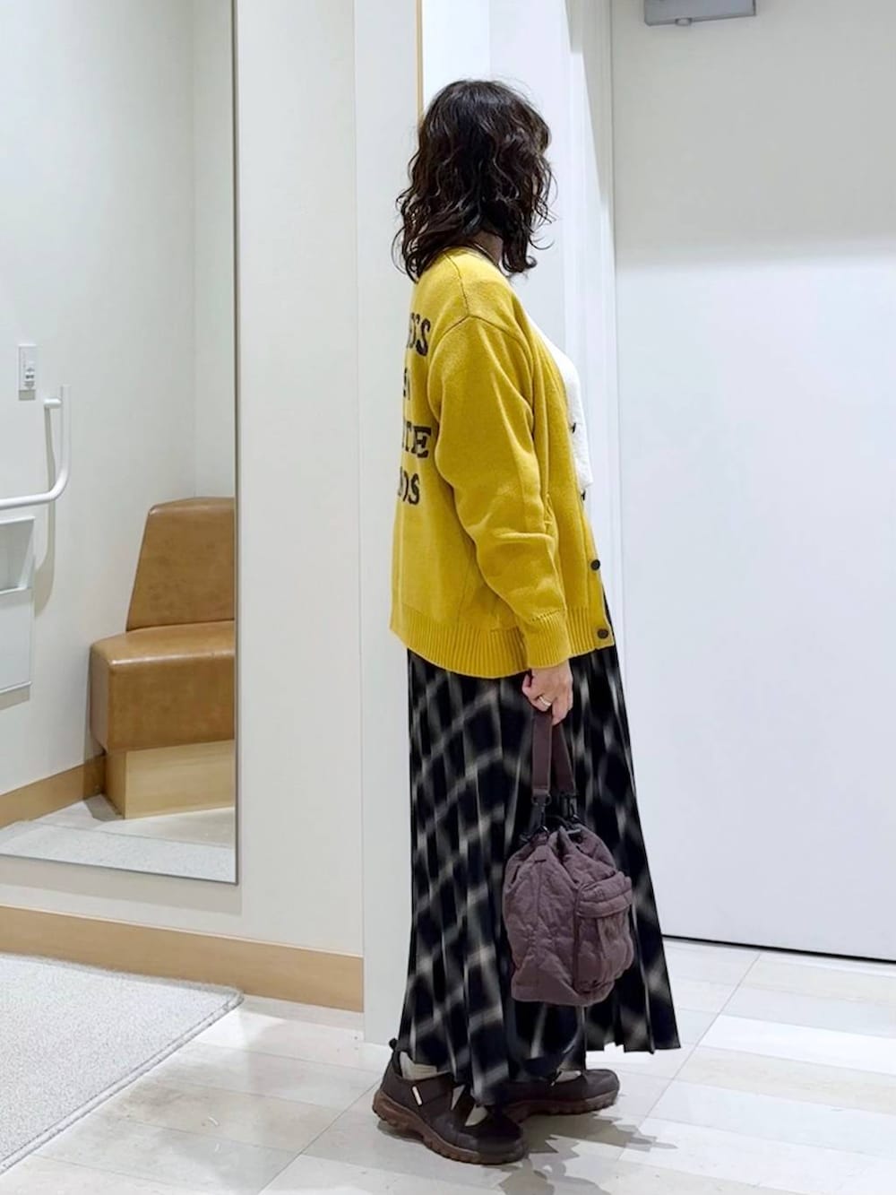 ブラウン系のスニーカー、ベージュ系のニット/セーター、ブラウン系のショルダーバッグを着用したレディースの秋コーディネートの3枚目の写真