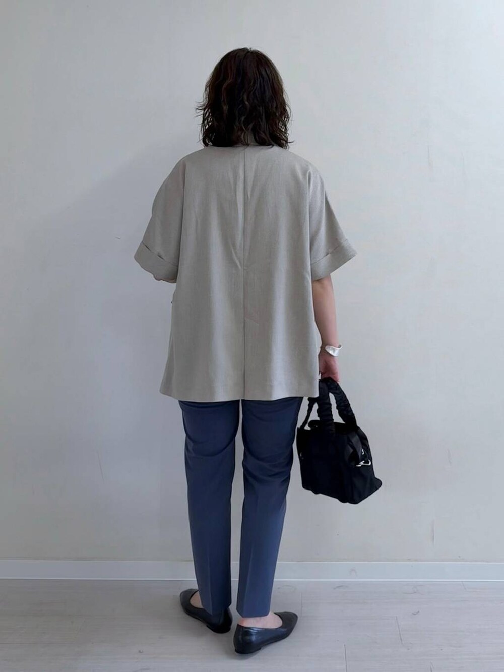 ブラック系のパンプス、ブルー系のその他パンツ、ブラック系のショルダーバッグを着用したレディースの春コーディネートの4枚目の写真