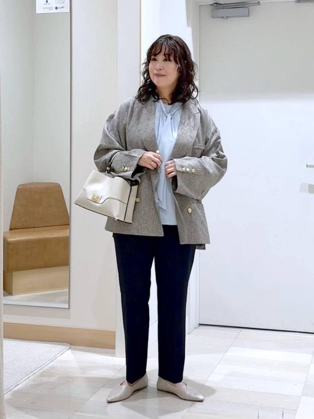 ホワイト系のパンプス、ブルー系のスラックス、ブルー系のシャツ/ブラウスを着用したレディースの春コーディネートの2枚目の写真