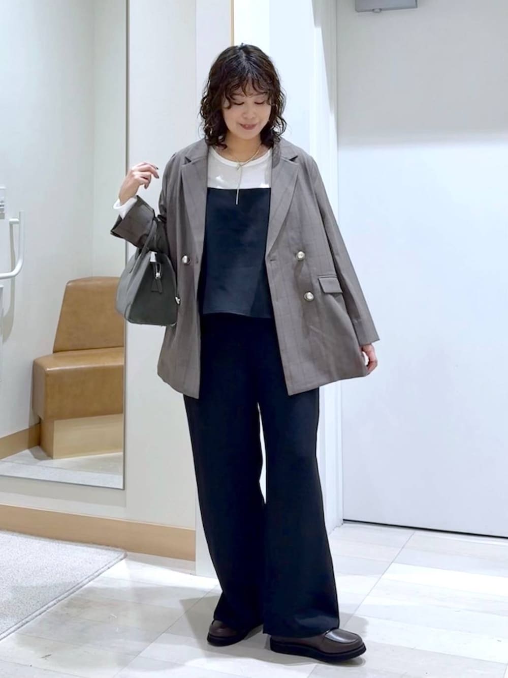 ブラウン系のローファー、グリーン系のショルダーバッグ、ブラック系のサロペット/オーバーオールを着用したレディースの秋コーディネートの2枚目の写真