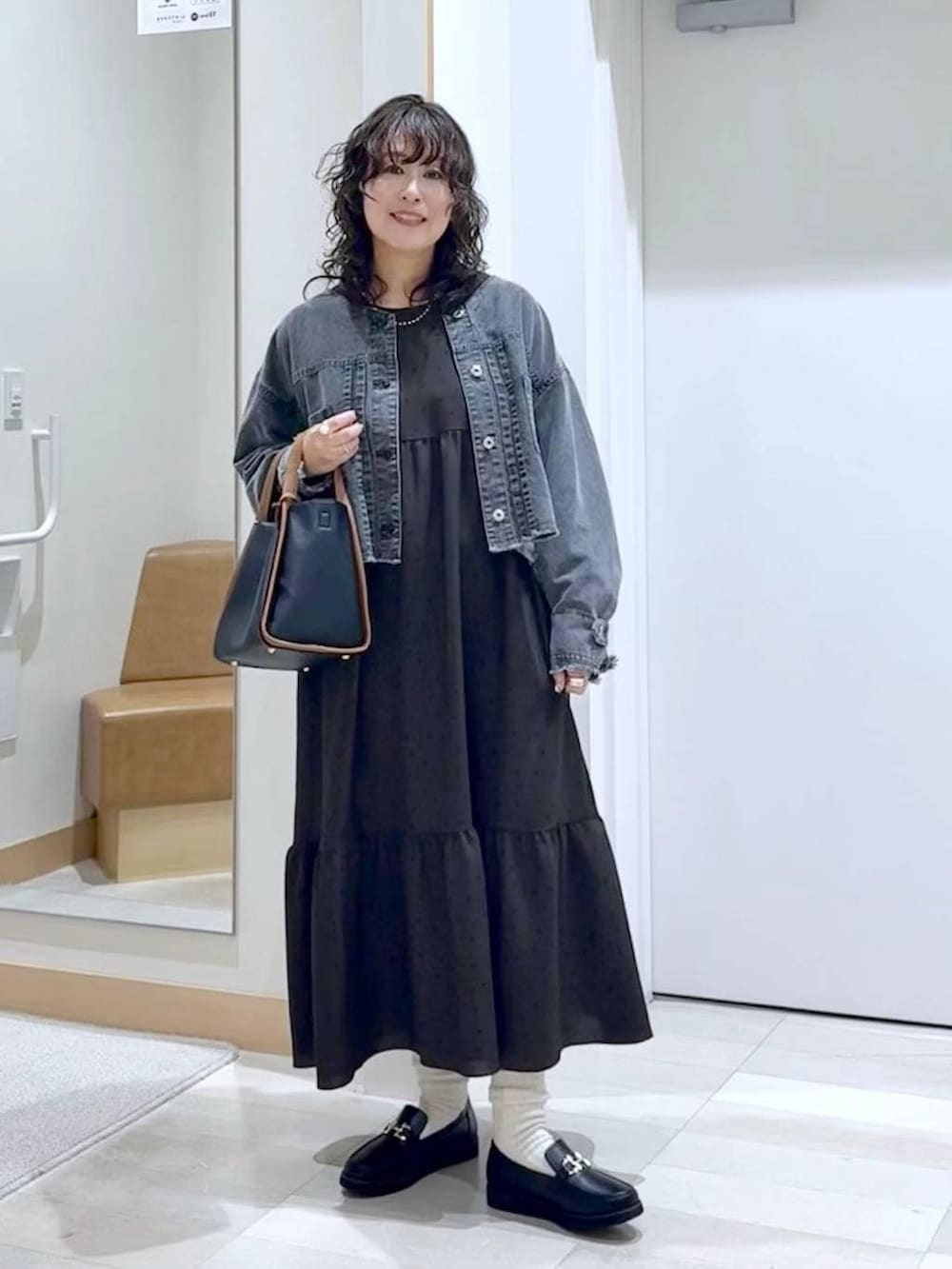 ブラック系のローファー、ブラック系のトートバッグ、ブラウン系のワンピースを着用したレディースの春コーディネートの2枚目の写真