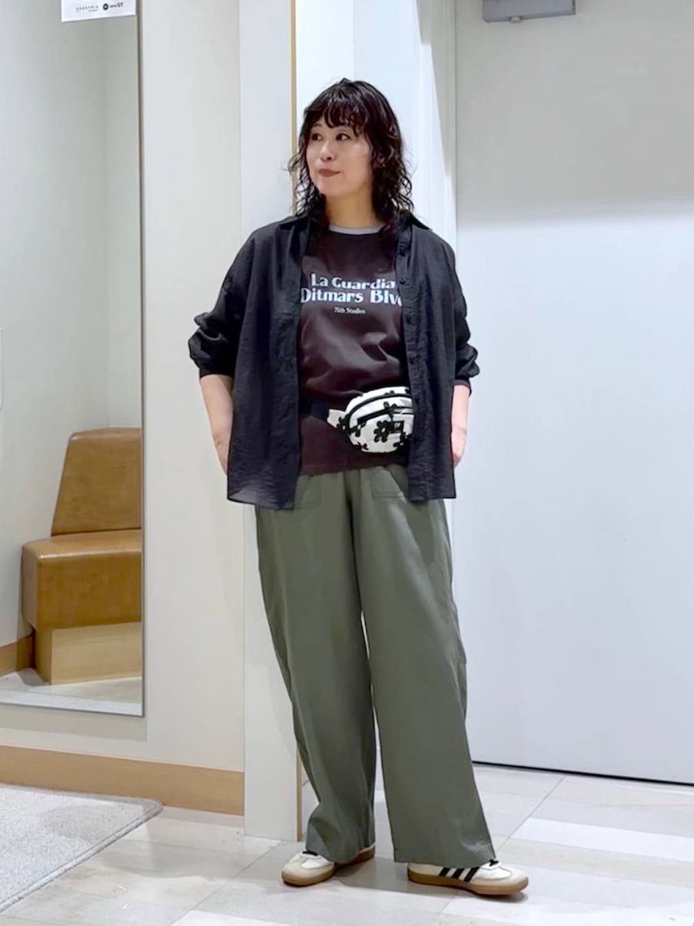 グレー系のシャツ/ブラウス、ホワイト系のボディバッグ/ウエストポーチ、ブラウン系のTシャツ/カットソーを着用したレディースの夏コーディネートの2枚目の写真