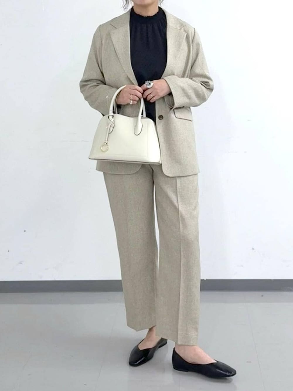 ブラック系のパンプス、ホワイト系のショルダーバッグ、ベージュ系のその他パンツを着用したレディースの春コーディネートの5枚目の写真