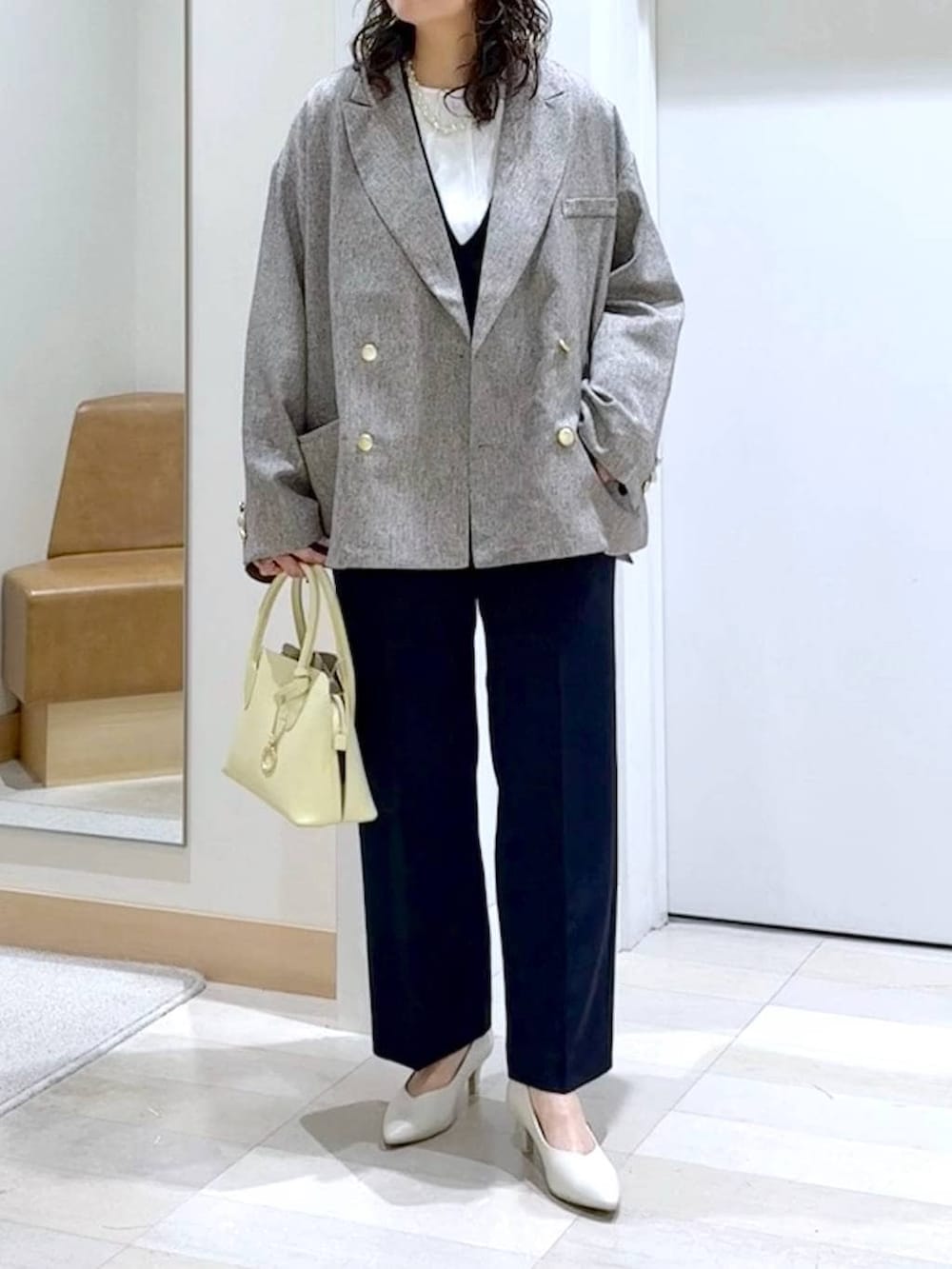 イエロー系のショルダーバッグ、ホワイト系のパンプス、ブルー系のセットアップを着用したレディースの春コーディネートの5枚目の写真