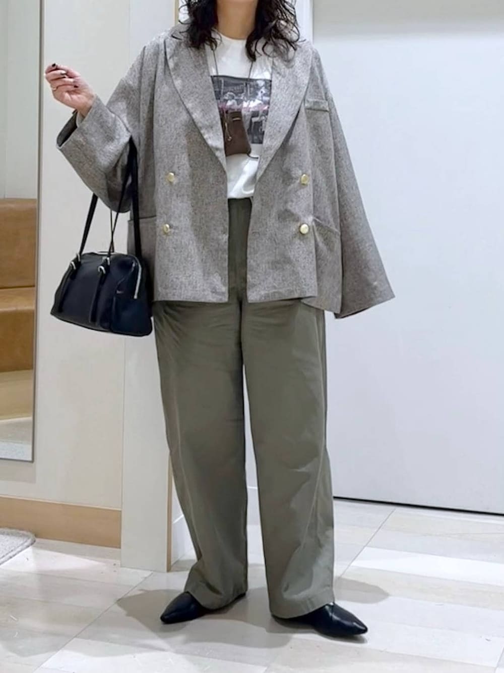 ブラック系のパンプス、ホワイト系のTシャツ/カットソー、ブラック系のショルダーバッグを着用したレディースの春コーディネートの5枚目の写真