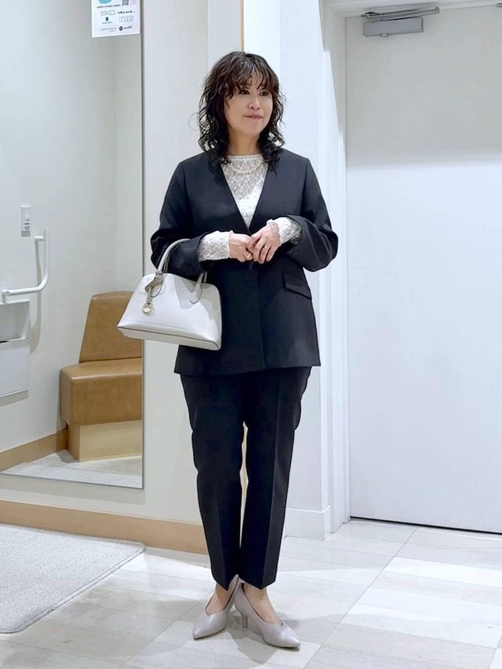 ホワイト系のショルダーバッグ、ホワイト系のパンプス、ホワイト系のTシャツ/カットソーを着用したレディースの冬コーディネートの2枚目の写真