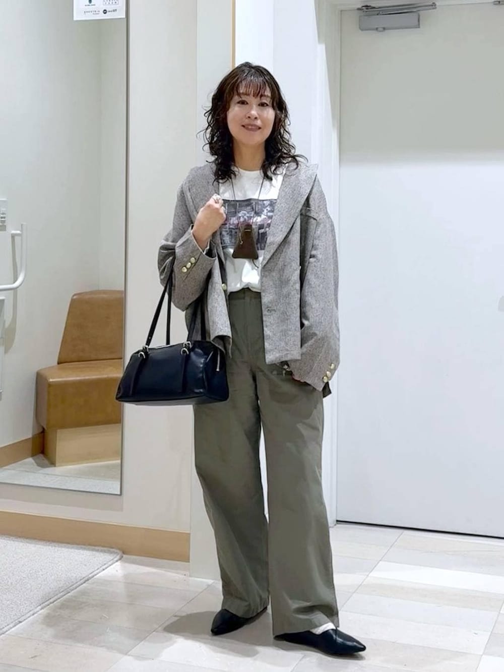 ブラック系のパンプス、ホワイト系のTシャツ/カットソー、ブラック系のショルダーバッグを着用したレディースの春コーディネートの2枚目の写真