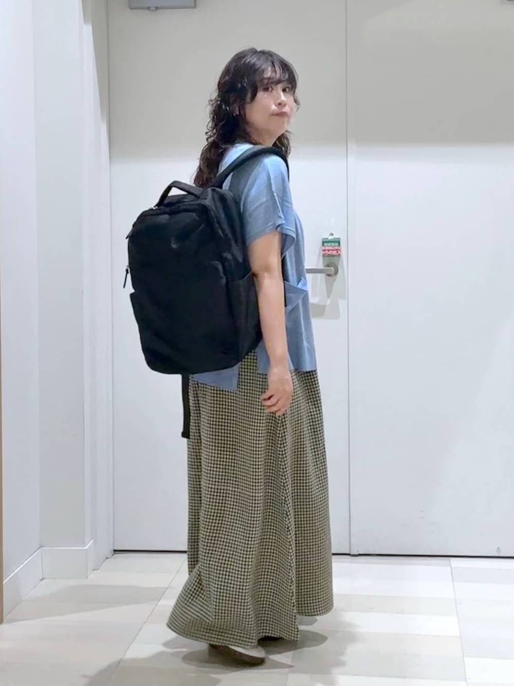 ブラック系のバックパック/リュック、ブラウン系のタンクトップ、ブルー系のカーディガン/ボレロを着用したレディースの春コーディネートの3枚目の写真