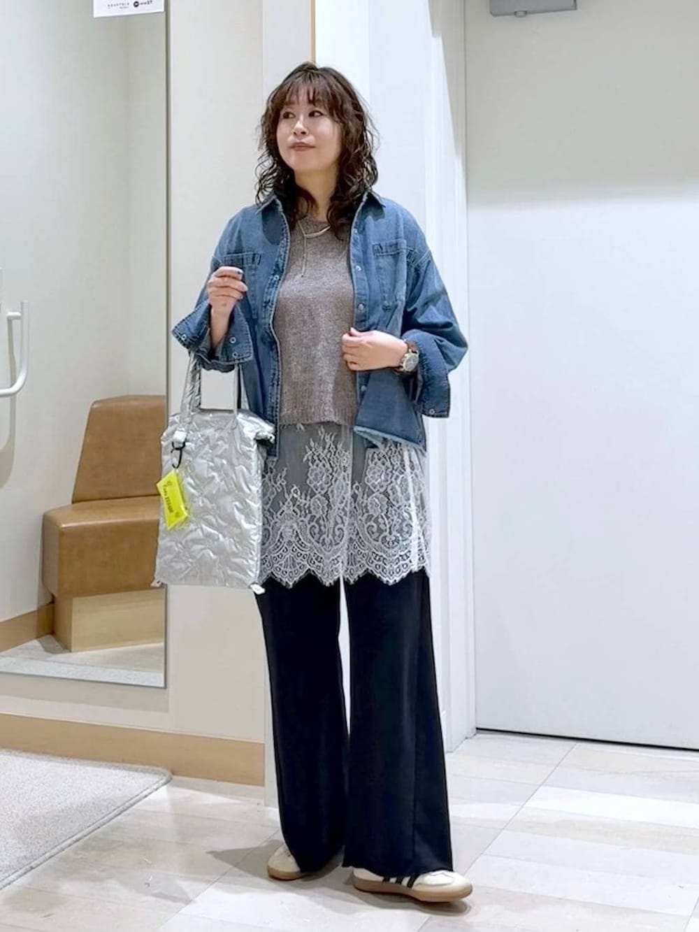 ブルー系のシャツ/ブラウス、ブラック系のスウェットパンツ、ベージュ系のニット/セーターを着用したレディースの春コーディネートの2枚目の写真